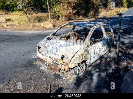 A city car burned out in a discreet street of a sensitive neighborhood. Stock Photo
