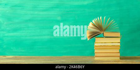 Opened Book on a pile of old books, panoramic, good copy space Stock Photo