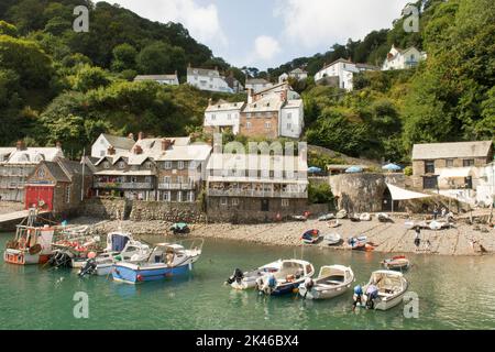 Clovelly. view of the village from the harbour wall showing the Red Lion Hotel, sea, boats and cottages, Devon coast, tide in with boats, Crazy Kate's Stock Photo