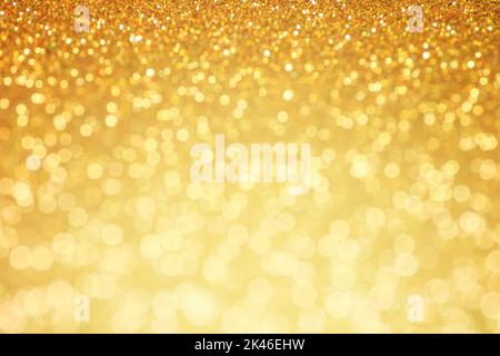 Golden glittering background. Sparkle glitter texture with the bokeh and the lights, shiny metal gold foil Stock Photo