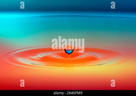 A floating drop above colored liquid Stock Photo - Alamy