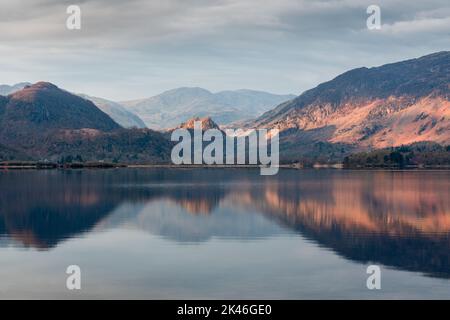 Borrowdale fells, including Castle Crag, reflected in Derwentwater, northwest English Lake District during sunrise on a calm spring morning Stock Photo