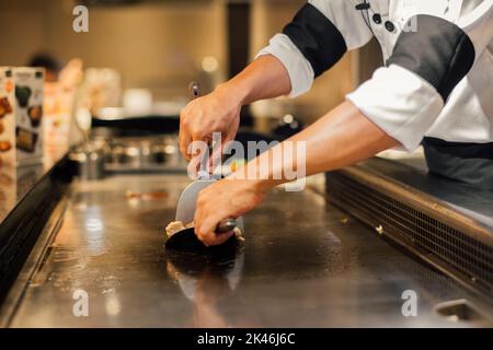 Hand of man take cooking of meat with vegetable grill, Chef cooking wagyu beef in Japanese teppanyaki restaurant Stock Photo