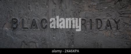 Black or dark gray grainy plaster texture background with text Black Friday Stock Photo