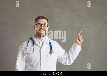 A young male doctor shows his forefinger to the top. Stock Photo