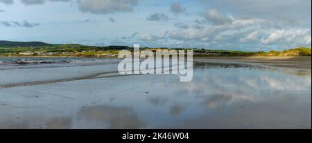 panorama landscape view of  Ballyheigue beach with reflections of sky and sand dunes Stock Photo