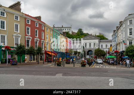 Cobh, Ireland - 15 August, 2022: town square in Cobh with colorful houses and the Lusitania Memorial statue Stock Photo