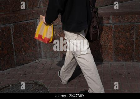 Kyiv, Ukraine. 30th Sep, 2022. A customer seen carrying a McDonald's paper bag on the street. Fast food chain McDonald’s has reopened 10 restaurants in Kyiv, resuming their dine-in service, first time after they closed all their restaurants in March. The fast food chain made a surprise announcement on their facebook account but warning there could be potential long queues. The chain has already reopened a handful of their restaurants 10 days ago but limited to takeaway service. Credit: Sipa USA/Alamy Live News Stock Photo