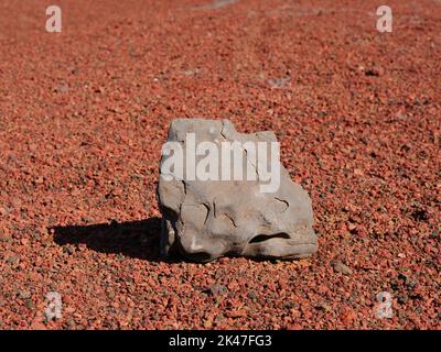 Stone on red ferruginous volcanic rock Stock Photo