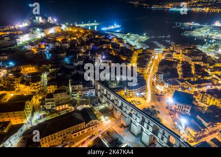 Aerial view the city of Kavala at night, in northern Greece, ancient aqueduct Kamares, homes and medieval city wall Stock Photo