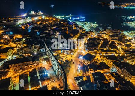 Aerial view the city of Kavala at night, in northern Greece, ancient aqueduct Kamares, homes and medieval city wall Stock Photo