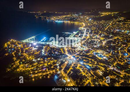 Aerial view the city of Kavala at night, in northern Greece, ancient aqueduct Kamares, homes and medieval city wall Stock Photo