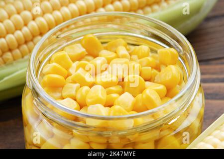 Pickled sweet corn in glass jar closeup, fresh and cooked corn on cobs. Stock Photo
