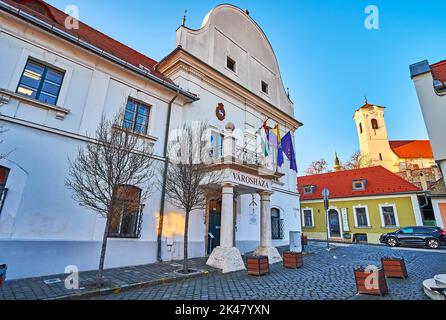 SZENTENDRE, HUNGARY - FEB 24, 2022: The clocktower of the Parish Church and the Town Hall building on Varoshaz Square, on Feb 24 in Szentendre Stock Photo