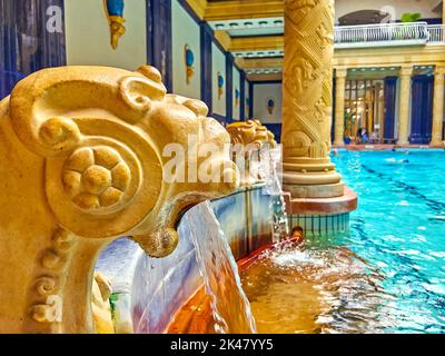 BUDAPEST, HUNGARY - FEB 24, 2022: The sculptured fountains of the swimming pool in Main Bath Hall of Gellert  Thermal Baths, on Feb 24 in Budapest Stock Photo