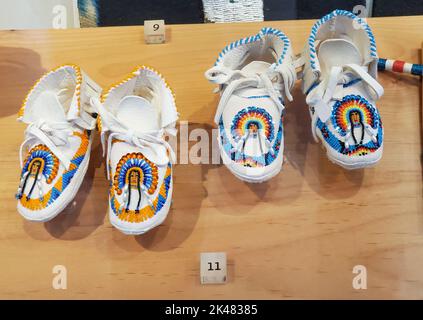 Two pair of white leather children's moccasins, piischui nuupacha, with beaded warrior in headdress. On display at the Museum of Northern Arizona in F Stock Photo