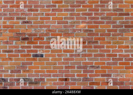 Full frame texture background of an antique red clay brick wall in traditional running bond pattern, with colorful weathered bricks Stock Photo