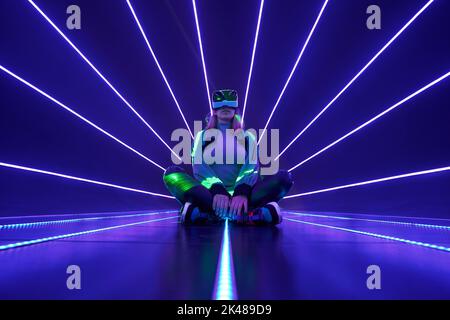 Woman is using virtual reality headset to access in metaverse. Concept of virtual, augmented and extended reality, future technology, artificial intel Stock Photo