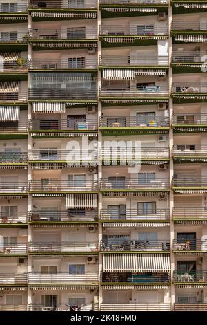 Balconies of a high-rise apartment building with facades, windows and awnings in the city center of Marbella in Spain. Stock Photo