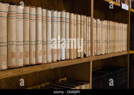 Old vintage books on a wooden shelf in the library Stock Photo