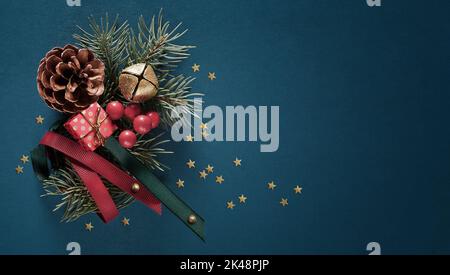 Christmas composition made of gift box, fir branches, cone, bell on a blue background. Flat lay, copy space Stock Photo