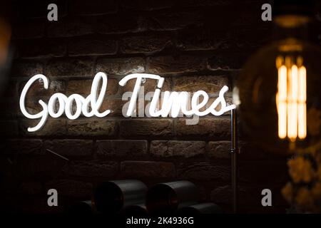 Good times neon sign lit up bright on brick wall background Stock Photo