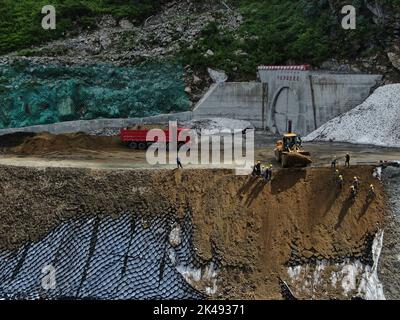 Lhasa, Tibet. 01st Oct, 2022. (221001) -- LHASA, Oct. 1, 2022 (Xinhua) -- Aerial photo taken on Aug. 18, 2020 shows the construction site of the Doxong Pass tunnel exit on the highway linking Pad Township in the city of Nyingchi and Medog County, southwest China's Tibet Autonomous Region. The 67.22-km road connects Pad Township in the city of Nyingchi and Medog County. It is the second passageway to Medog, following the first one connecting the county and Zhamog Township, Bomi County. After the new highway opens to traffic, the length of the road connecting the city proper of Nyingchi and Medo Stock Photo