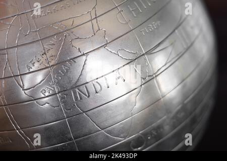 Hand carved engraved metal world globe showing the country of India prominently Stock Photo