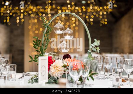 Beautiful candle light wedding table decor with flowers and out of focus twinkle lights. Wedding breakfast party. Stock Photo