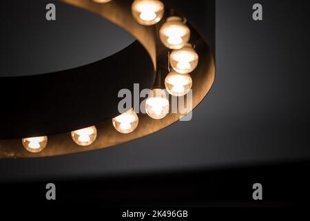 Retro industrial light with multiple electric bulbs lit up turned on. Stock Photo