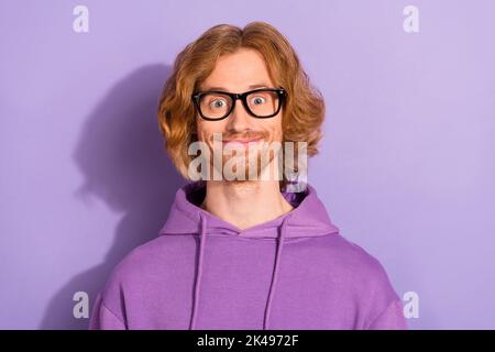 Photo of geek curly orange hairdo guy wear spectacles violet hoodie isolated on purple color background Stock Photo