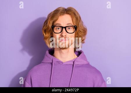 Photo of funny wavy orange hairdo guy wear eyewear violet hoodie isolated on purple color background Stock Photo