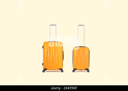 Stylish yellow suitcases isolated on yellow background Stock Photo