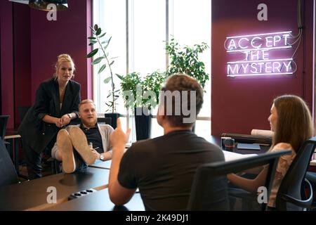 Design professionals discussing architectural drawings in company office Stock Photo