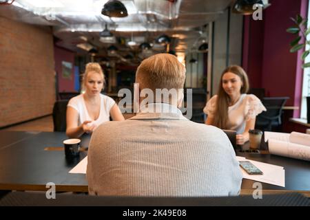Group of architects discussing construction drawings at meeting Stock Photo