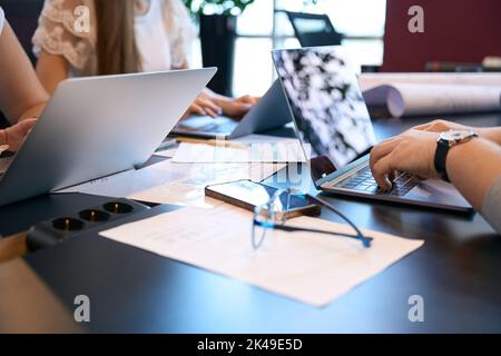 Group of architects working on laptops at new building project Stock Photo