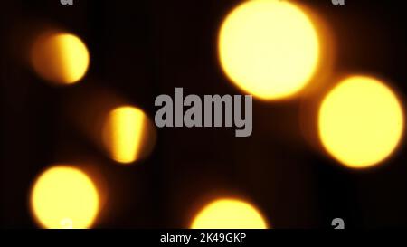 Abstract bokeh background in motion. shining, blurred golden particles, lights. bright bokeh from garlands on dark background. New year or Christmas festive backdrop. High quality photo Stock Photo