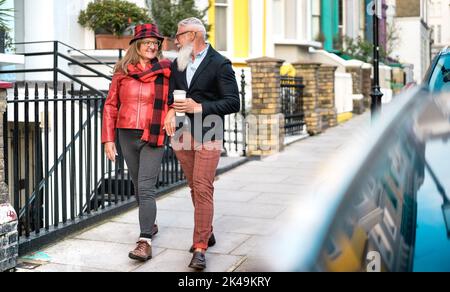 Happy senior couple walking holding hand in Notting Hill in London City - Active elderly and travel lifestyle concept with retired mature people at En Stock Photo