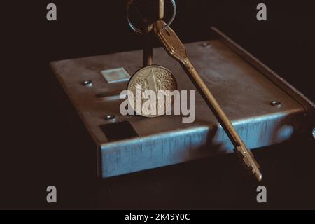 Conceptual crisis real estate, door keys and lock with Ukrainian hryvnia coin on a black background, conceptual crisis of the economy on world Stock Photo