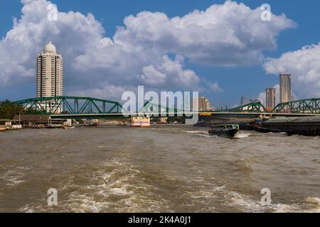 Bangkok, Thailand.  Memorial Bridge over the Chao Phraya River.  Bangkok River Park, a Condominium, in Background on left. Stock Photo