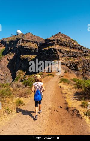 A young woman walking towards Pico do Arieiro from Ninho da Manta viewpoint, Madeira. Portugal Stock Photo