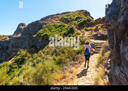 A young woman walking towards Pico do Arieiro from Ninho da Manta viewpoint, Madeira. Portugal Stock Photo