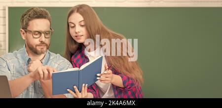 Father and daughter at school, teacher and pupil banner. attentive teen girl and teacher man in high school with workbook and pc at blackboard Stock Photo