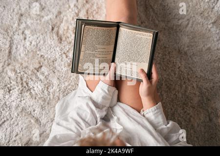 Crop woman reading book at home Stock Photo