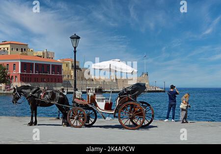 Venetian harbour, horse-drawn carriage and tourists, Chania, Crete, Greece Stock Photo