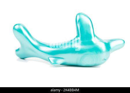 A stylized turquoise dolphin figurine. Isolated over white background. Close-up. Stock Photo