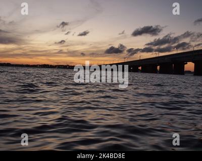 Late afternoon sunset over Barnegat Bay, New Jersey. The bridge is the Mathis Bridge carrying NJ State Highway 37 to and from Seaside Heights NJ Stock Photo