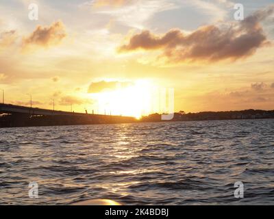 Late afternoon sunset over Barnegat Bay, New Jersey. The bridge is the Mathis Bridge carrying NJ State Highway 37 to and from Seaside Heights NJ Stock Photo