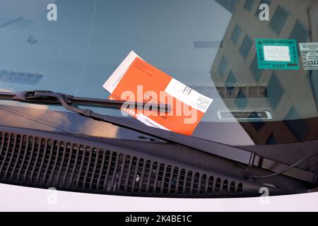 A NYC Parking ticket and payment envelope on the windshield of a motor vehicle in New York City. Stock Photo