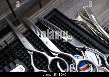 Vintage barber shop tools on old wooden background and rubber mat. Stock Photo